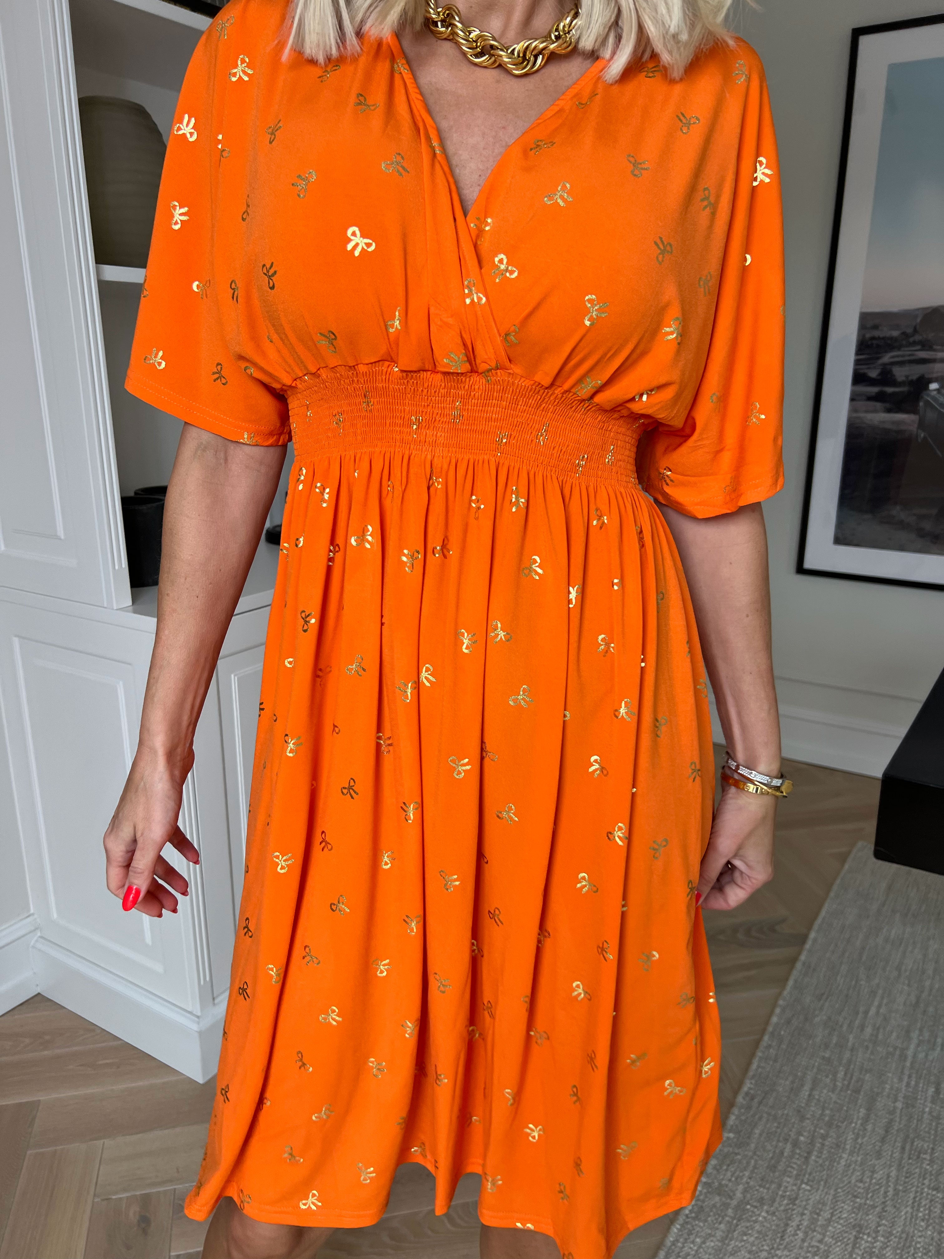 Pams Gold Bow Short - Elastisk kjole med smock i livet og fine guld sløjfer